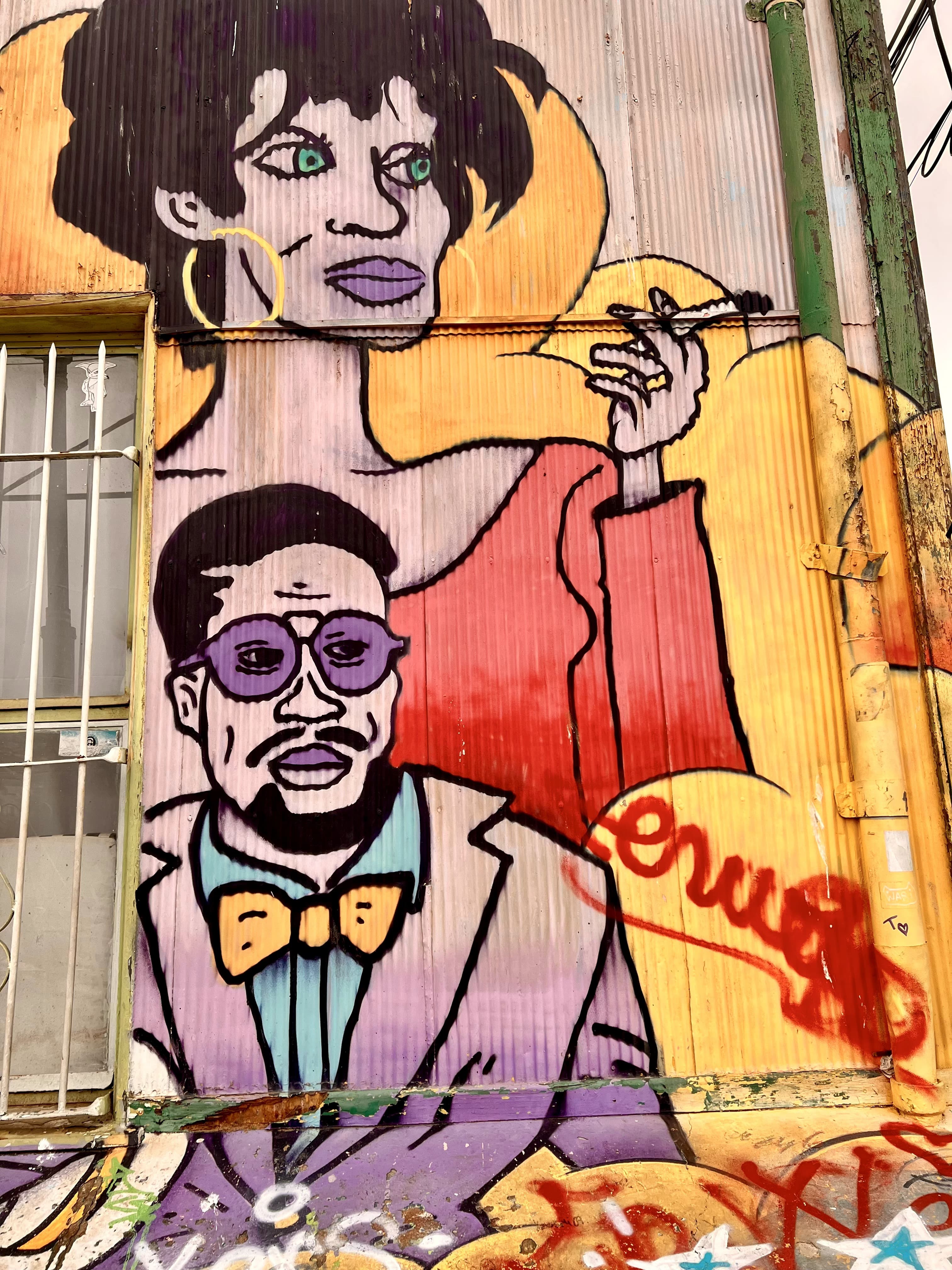 Colourful street art mural of two figures on a corrugated iron wall, Valparaíso, Chile
